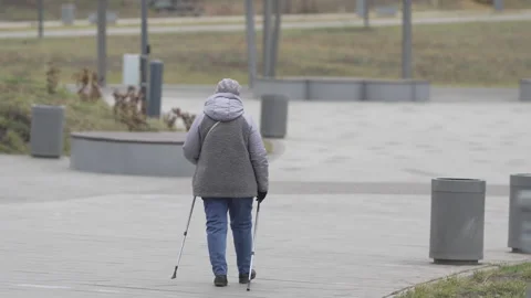 Older person walks on path with walking poles for exercise Stock Footage 306450166