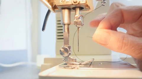 Older Seamstress Threads a Sewing Machine Needle in 4k Stock Footage 88604071