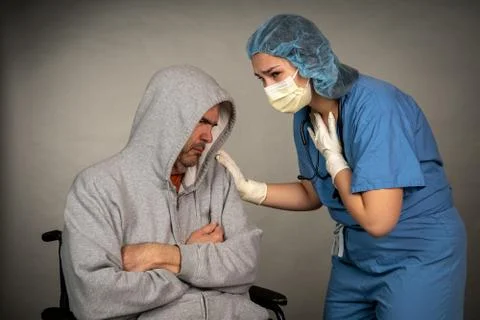 Older sick man being cared for by a young nurse Stock Photos
