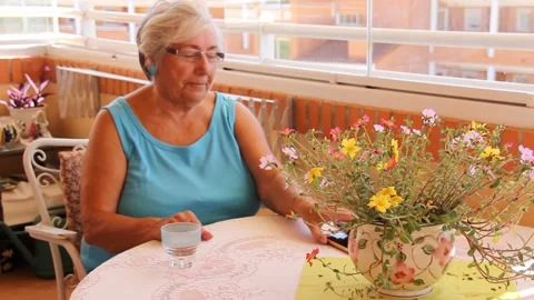 Older Woman on a Balcony Checking Smartphone 動画素材 136048853