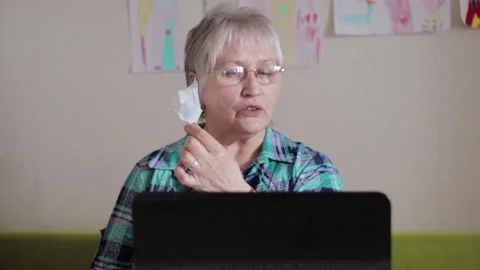 Older woman in protective medical mask at a laptop. Stock Footage