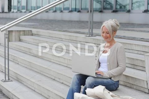 Older Woman Using Laptop On Steps