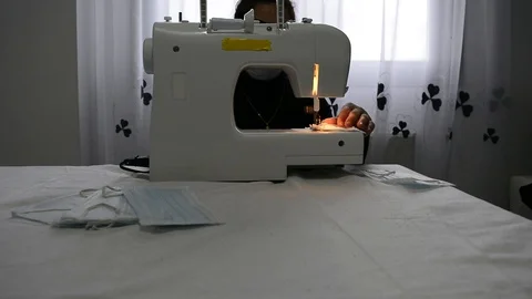 Older woman volunteers sewing masks to combat the virus. Stock Footage