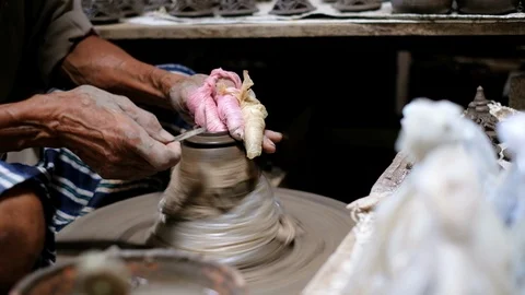 Oldman shaving the clay pot lid for perfect shape Stock Footage 100733475