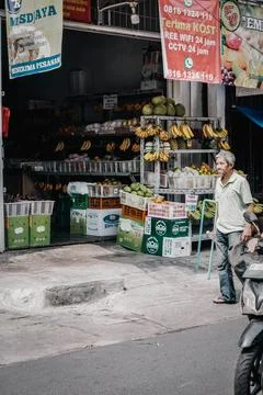 An oldman walked in front of a fruit store Stock Photos