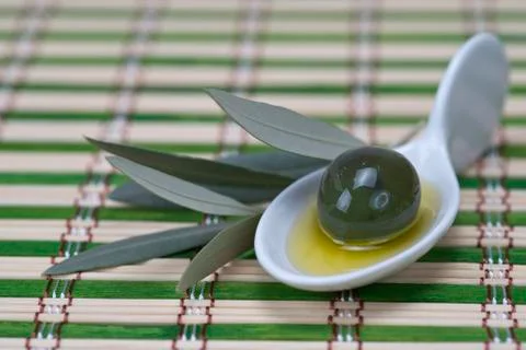 Olive in a china spoon Stock Photos