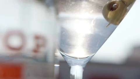 Olive Dropped into Martini Glass Stock Footage