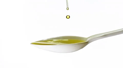 Olive Falling into Spoon with Olive Oil against White Background, Slow Motion Stock Footage