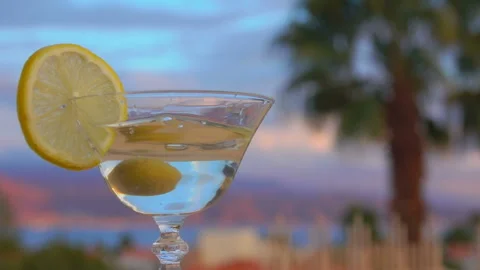 An olive falls into the sides of a martini Stock Footage 212579875