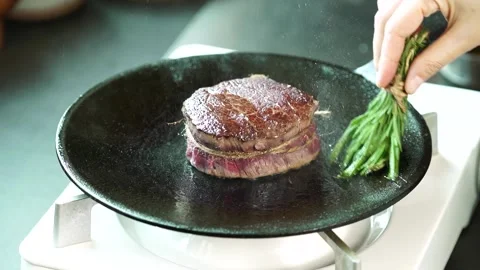 Olive oil is applied to the steak over the pan. 動画素材 334358094