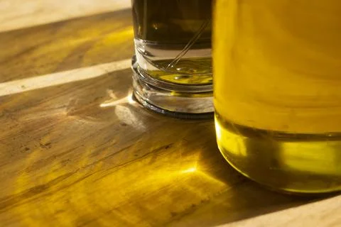 Olive oil bottle on wooden cutting board in modern kitchen interior Stock Photos