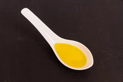 Olive oil on ceramic spoon Stock Photos
