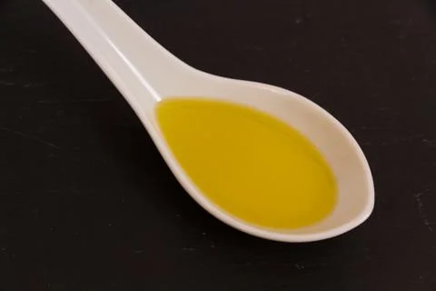 Olive oil on ceramic spoon Stock Photos