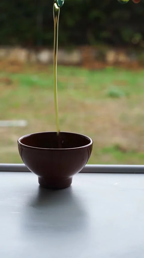 Olive oil falling into a container Stock Footage 250765074