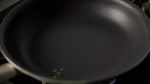 Olive Oil Heating in Pan Over Gas Flame Stock Footage 313047367