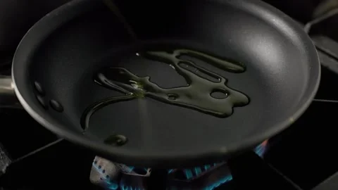 Olive Oil Heating in Pan Over Gas Flame Stock Footage 313047417