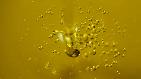 Olive oil jet pours elegantly with visible air bubbles Vídeo Stock 333988009