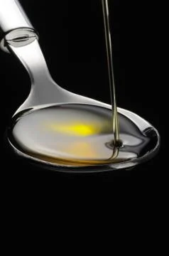 Olive oil on a spoon Stock Photos