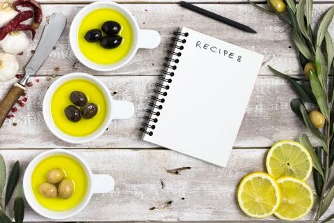 Olive oil themed background with an empty notebook Stock Photos