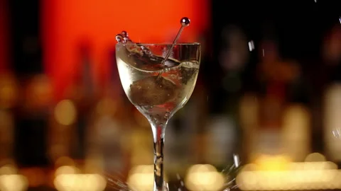Olive on a skewer is falling to the cocktail with splash in 240fps slow motion Stock Footage 157769523