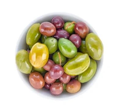 Olives of different grades and sizes in a porcelain bowl. Top view close up. Stock Photos
