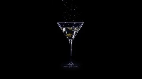 Olives fall in a glass for martini with splashes Stock Footage 72476789