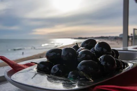 Olives platter overlooking the beach Stock Photos