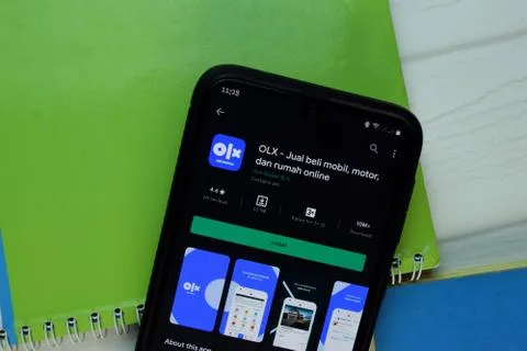 OLX Online Shopping dev app with magnifying on Smartphone screen. Stock Photos