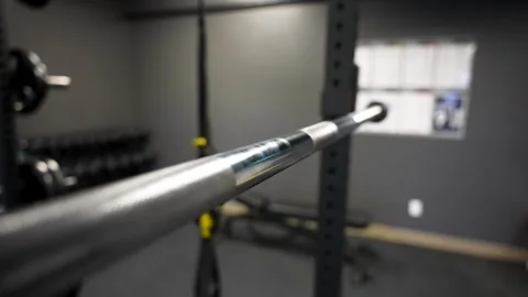 Olympic barbell close up on squat rack inside modern studio gym Stock Footage 330620668
