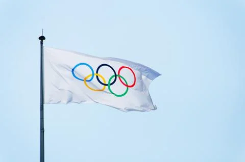 Olympic flag, blue sky background Stockfoto's