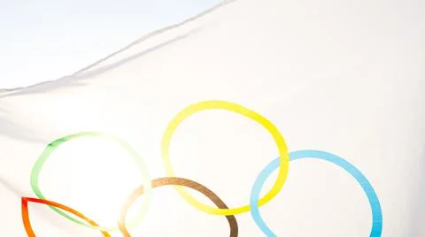 The Olympic flag flutters in the wind against the background of the sky and t 스톡 사진