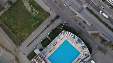 Olympic swimming pool sports complex beside coastal road and city Stock Footage 343994015