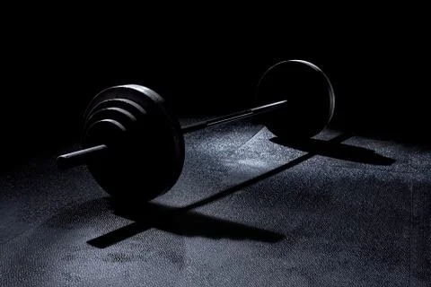 Olympic weights in gym with dramatic lighting Stock Photos