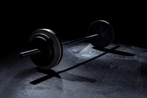 Olympic weights in gym with dramatic lighting Stock Photos
