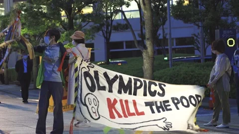 "Olympics Kill the Poor" - protestors take a stand against the Tokyo Olympics Stock Footage 154897764