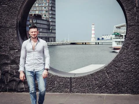 OLYMPUS DIGITAL CAMERA Handsome, stylish guy strolls along the sea embankment Stock Photos