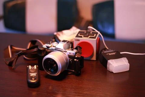 Olympus OM-D E-M10 Mark II camera, flash lamp and Portable speaker on a wooden t Stock Photos
