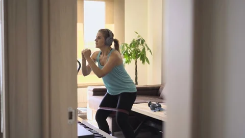 Oman doing exercises with an elastic band in the living room at home. Healthy Stock Footage 127117323