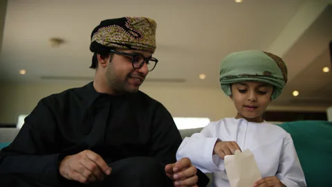 Omani father giving eidi to son. Stock Footage 151278460