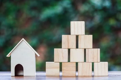 Ome model and stack empty wooden square block or cube on wood table. Stock Photos
