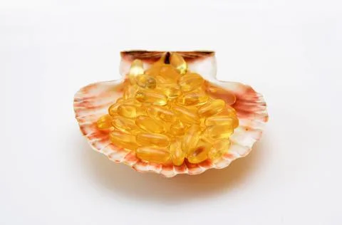 Omega 3 capsules in a shell close-up conceptual photo Stock Photos