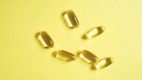 Omega 3 capsules on yellow background close-up top view. Stock Footage 200638541