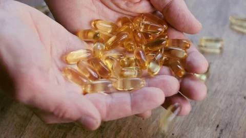 Omega 3 capsulese in the hands Video stock 72372459
