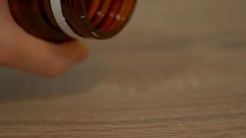 Omega 3 drop from the bottle to the table. Macro view to the pills Stock Footage 148435191