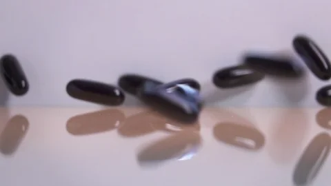 Omega-3 fatty acids falling on reflective surface, slow motion 스톡 동영상 88742586