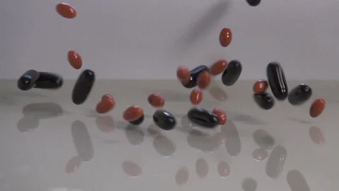 Omega-3 fatty acids falling on reflective surface, slow motion Stockbeeldmateriaal 88742760