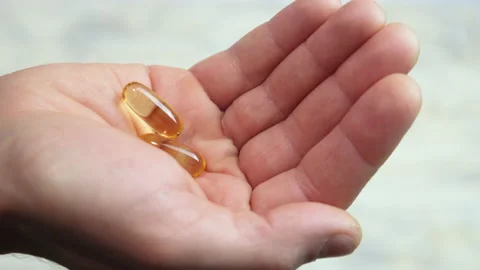 Omega 3 vitamins in hand. selective focus Stock Footage 146942636