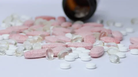Omega-3 yellow tablets with fish oil and other vitamins fall on the wrinkled Stock Footage 182032094