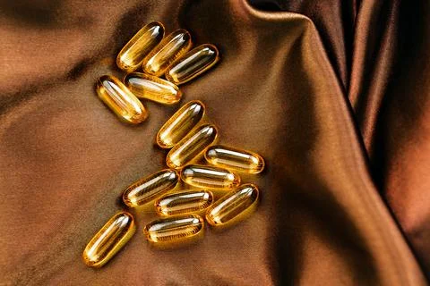 Omega3 softgel capsules on silk background Stock Photos