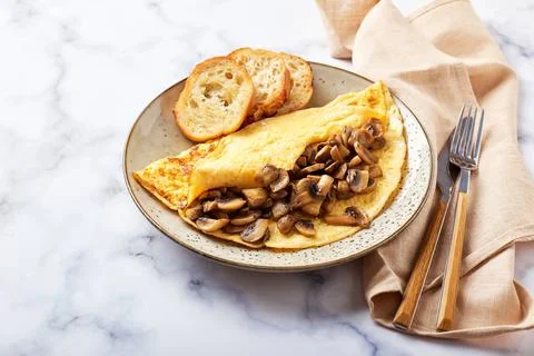 Omelet with champignons in plate on marble background. Frittata - italian omelet Stock Photos